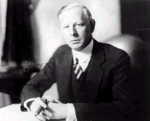 Chân dung Jesse Livermore ngồi tại bàn làm việc cùng điếu xì gà